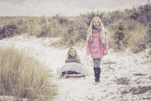 Sisters in the snow wearing wooden Scarves & Jumpers