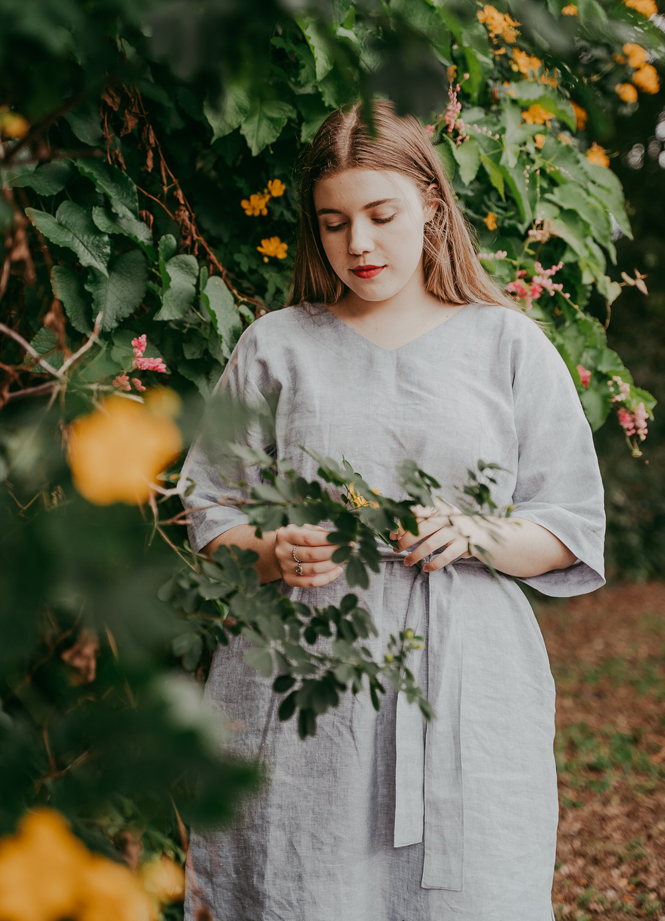 woman modeling plus size dress pattern offered that has mid sleeves and ties at the waist