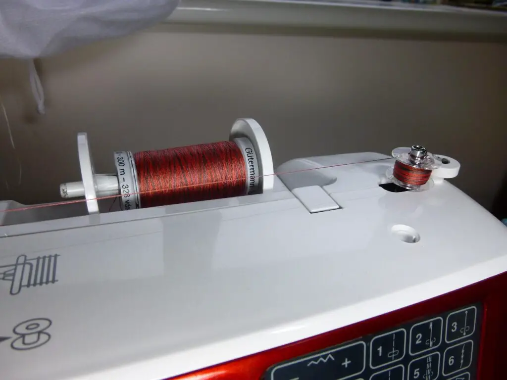 winding a bobbin with brown thread on a sewing machine